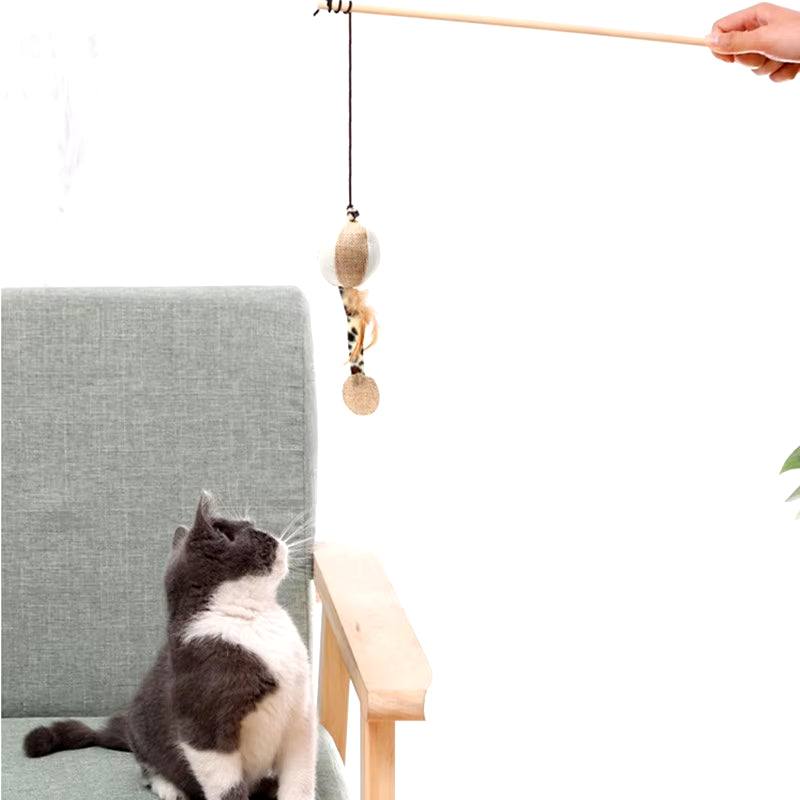 Colorful feather cat toy with long wand, engaging kitten in playful interaction.